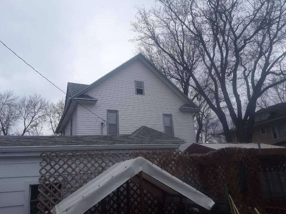 A two-story home buttoned up with a fresh gray architectural-shingle roof before a South Dakota winter.