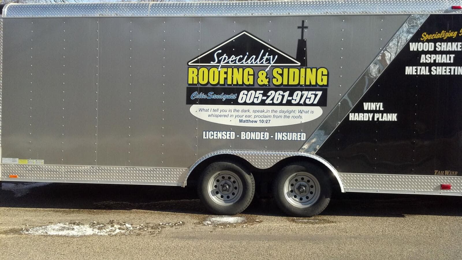 Specialty's branded enclosed work trailer, lettered Licensed, Bonded, Insured.